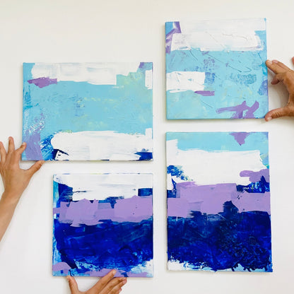Vier originale Kunstwerke in den Farben Blau, Lila und Weiß von FLOR. hängend in einem Zuhause. 