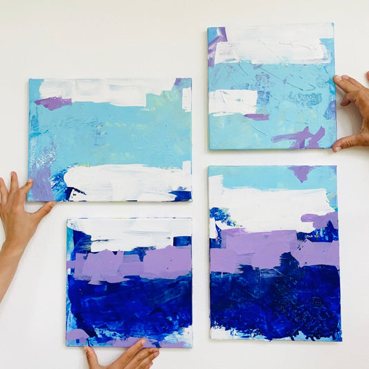 Vier originale Kunstwerke in den Farben Blau, Lila und Weiß von FLOR. hängend in einem Zuhause. 
